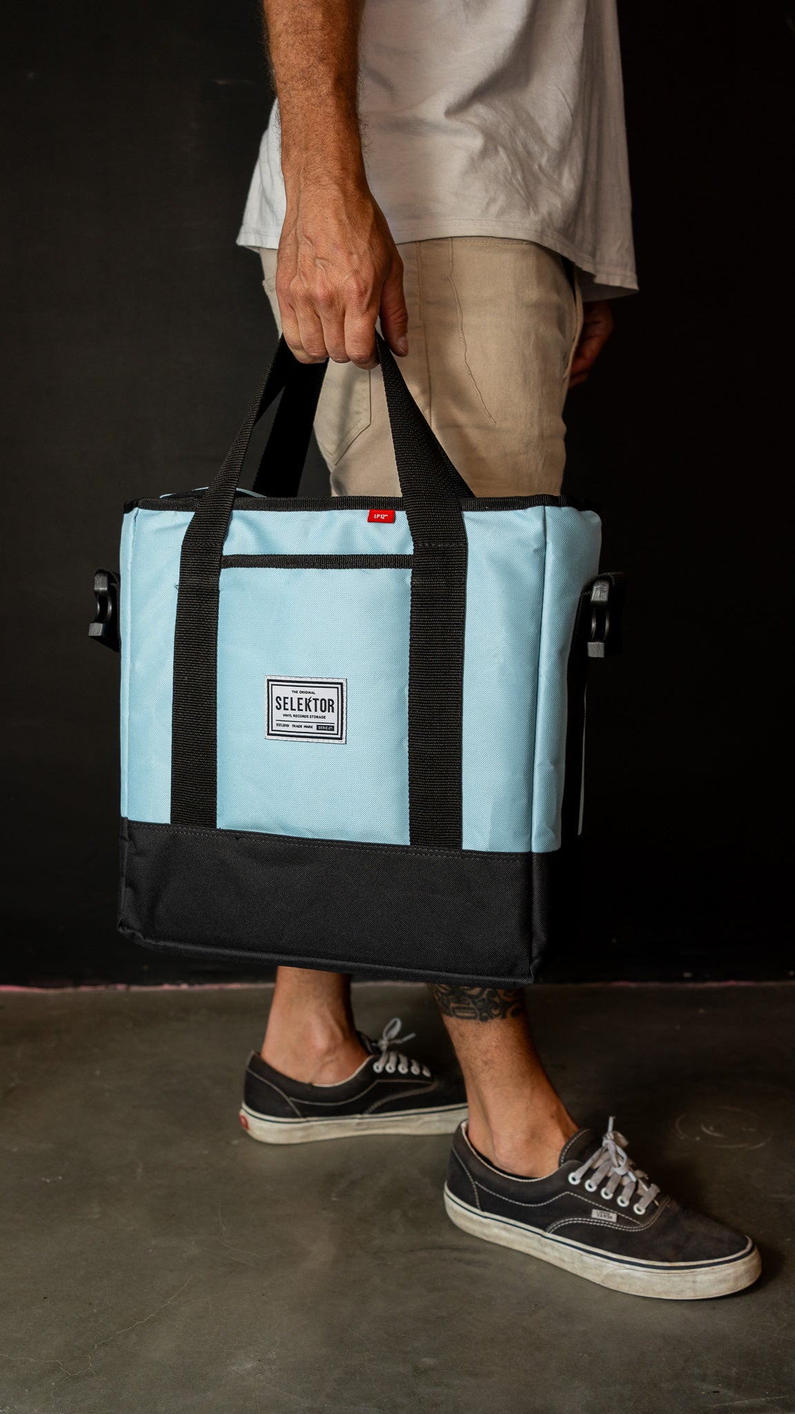 Selektor Messenger Bag, Light Blue and Black, Side View, Hand Held